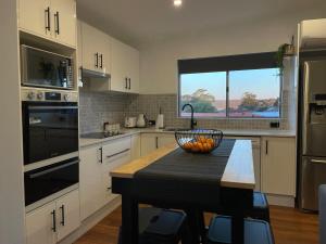 a kitchen with a table with a bowl of fruit on it at Serene Haven in Sanctuary Point in Sanctuary Point