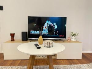 a living room with a tv and a white table at Serene Haven in Sanctuary Point in Sanctuary Point