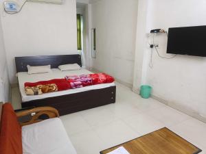a bedroom with a bed with a red blanket at Hotel O Couples Hotel in Jamshedpur