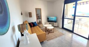 a living room with a couch and a television at Sea View Appartement Blue Monkey in Ifach