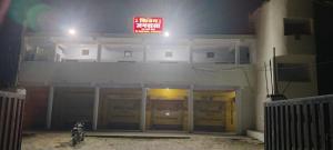 a building with a neon sign in front of it at Shivam hotel rewa and janmasa in Rewa