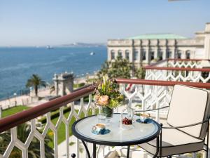 a table on a balcony with a view of the ocean at Çırağan Palace Kempinski Istanbul in Istanbul