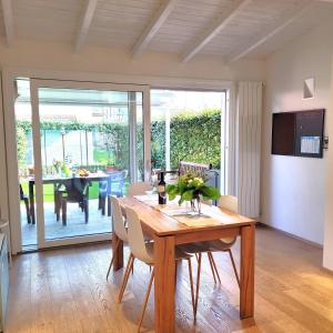 a dining room with a wooden table with chairs and a dining room at Casa Gianpi Mountain Lake Iseo Hospitality in Pisogne