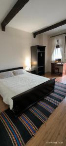 een slaapkamer met een groot bed en een tapijt bij Андреева къща in Zlatograd