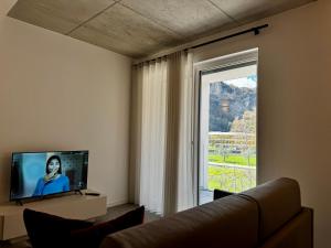 a living room with a couch and a large window at 1Dest - Rock'n'River - Flat in Arco