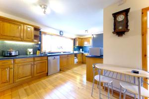 una cucina con armadi in legno e un orologio sul muro di Suilven Cottage a Tain Altre 15 foto