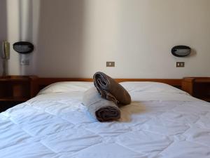 a bed with a pile of towels on it at Hotel New Arpa in Rimini
