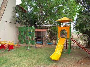 a playground with a slide in a yard at Arav Resort in Katrab