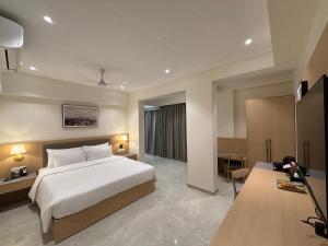 a hotel room with a bed and a television at Mastiff Hotel Hinjawadi Pune in Pune +84 photos
