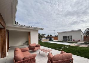 a patio with chairs and a table on a house at Villa Karasse in Lège-Cap-Ferret