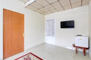 a room with a door and a tv on the wall at Hotel O Homestay Ayana Syariah in Yogyakarta