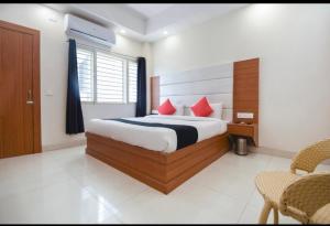 a bedroom with a bed with red pillows at Hotel yours pacific in Dehradun