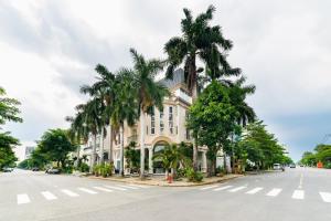 a building with palm trees on the side of a street at Collection O Sunshine Garden Hotel - Near SECC in Ho Chi Minh City