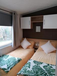 two beds in a small room with a window at 3Bed 2Bath Quiet woodland cul de sac! in Lymington