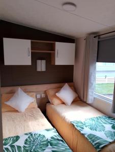 a room with two beds in the back of a caravan at 3Bed 2Bath Quiet woodland cul de sac! in Lymington