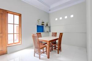 a dining room with a wooden table and chairs at Hotel O D'draman Homestay Syariah in Wanujoyo