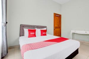 a bedroom with a bed with red pillows at Hotel O D'draman Homestay Syariah in Wanujoyo