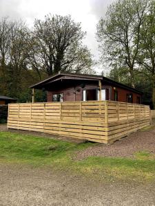 a house with a wooden fence in front of it at The Woodhouse Cabin 8 in Moffat +14 photos