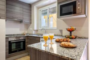 a kitchen with two glasses of orange juice and bread at Loft Sant Joan in L'Ametlla de Mar