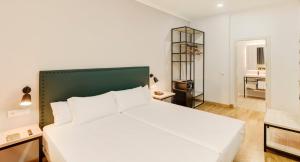 a bedroom with a large white bed in a room at Sercotel Las Casas de los Mercaderes in Seville
