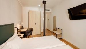a bedroom with a bed and a desk and a deskablish at Sercotel Las Casas de los Mercaderes in Seville