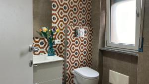 a bathroom with a toilet and a window at Le Suites di Teodoro in Maiori