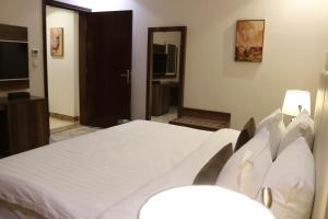 a bedroom with a large white bed in a room at PRIMOTEL Grand Al Taoubah in Jeddah