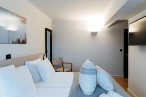 a bedroom with a white bed with white pillows at Boutique Hotel Azur in De Haan