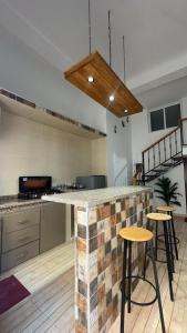 a kitchen with a brick counter and bar stools at Loft Apartament Chaouen in Chefchaouen