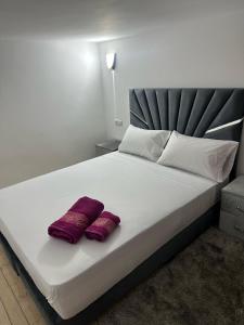 a bed with two red pillows on it at Loft Apartament Chaouen in Chefchaouene