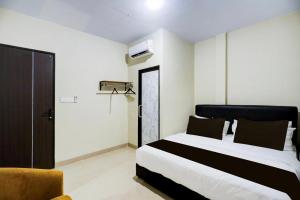 a hotel room with a bed and a chair at Collection O Near UNRIKA Formerly Dory Inn in Sekupang