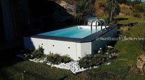 a swimming pool in a garden with a fountain at Villetta Belvedere con Jacuzzi in Porto Cervo