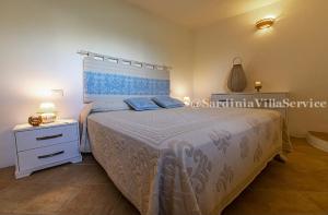 a bedroom with a bed with a blue and white bedspread at Villetta Belvedere con Jacuzzi in Porto Cervo +15 photos