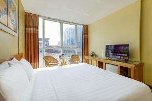 a hotel room with a large bed and a television at Collection O Le Grand Hanoi hotel - The Sun in Hanoi