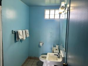 a blue bathroom with a toilet and a sink at Westgate Manor Motel Austintown & Youngstown OHIO in Youngstown +60 photos