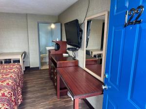 a hotel room with a dresser with a mirror at Westgate Manor Motel Austintown & Youngstown OHIO in Youngstown
