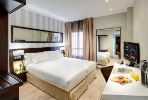 A bed or beds in a room at Sercotel Madrid Aeropuerto