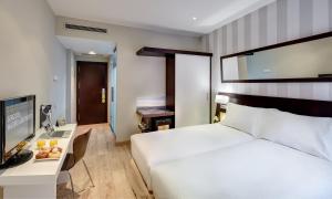 A bed or beds in a room at Sercotel Madrid Aeropuerto