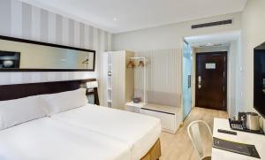A bed or beds in a room at Sercotel Madrid Aeropuerto