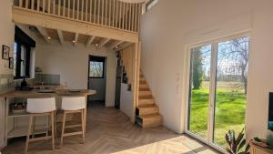 a room with a staircase and a kitchen with a table and chairs at Tiny Tranquille in Sailly-lès-Lannoy