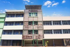 an office building with a tower on top of it at Collection O Bukit Kecil Near Palembang Indah Mall Formerly Hostel 77 in Palembang