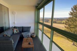 a living room with a couch and a large window at Apartment mit Grüner Aussicht im Schwarzwald in Löffingen