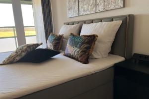 a bed with four pillows on it with a window at Apartment mit Grüner Aussicht im Schwarzwald in Löffingen