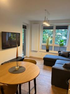 a living room with a table and a couch at Apartament Julia 1-4 os Starowapiennikowa 42a z balkonem, klimatyzacją i miejscem parkingowym in Kielce