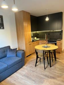 a living room with a blue couch and a table at Apartament Julia 1-4 os Starowapiennikowa 42a z balkonem, klimatyzacją i miejscem parkingowym in Kielce