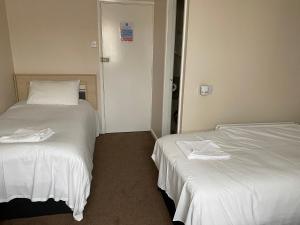 two beds sitting next to each other in a room at The Arncliff Hotel in Blackpool