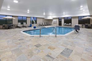 a pool in a large room with tables and chairs at Hampton Inn Cleveland-Airport/Tiedeman Road in Brooklyn