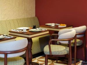 a restaurant with two tables and chairs with food on them at ibis Styles Paris Boulogne Marcel Sembat in Boulogne-Billancourt