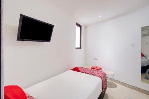 ジャカルタにあるTownhouse Oak Gunung Sahari Near Ancolの白い部屋(ベッド1台、薄型テレビ付)