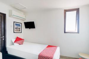 ジャカルタにあるTownhouse Oak Gunung Sahari Near Ancolのベッドと窓のある白い部屋